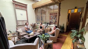 A cozy indoor setting with two sofas, a coffee table, and various plants. - Coliving Granada (Envigado)
