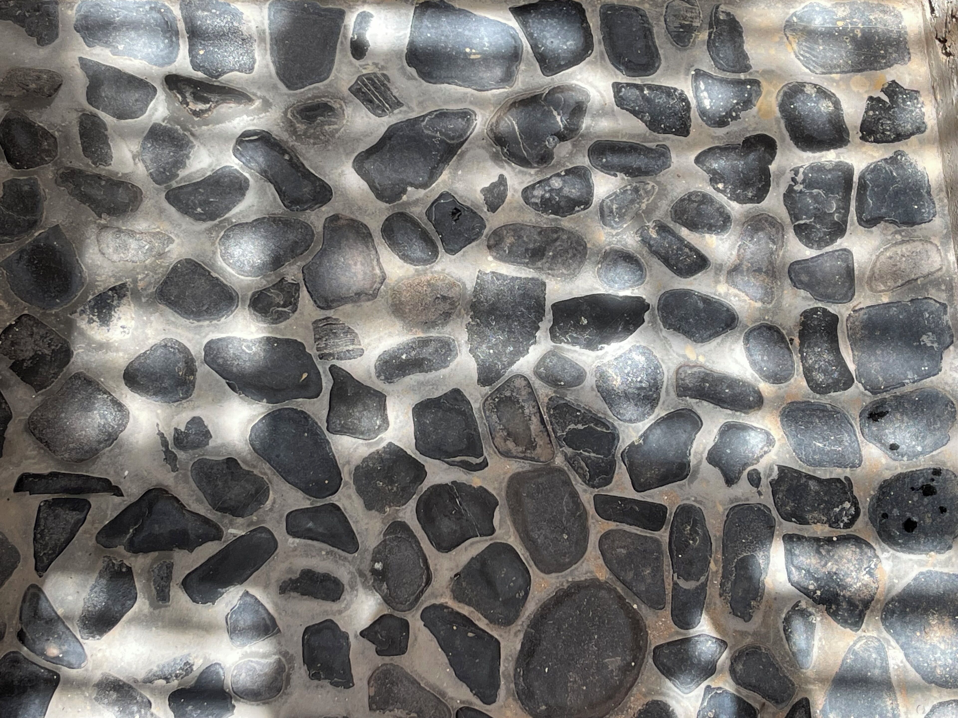 A close-up of a stone floor with irregularly shaped stones.