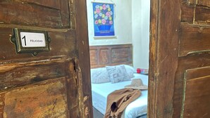 A wooden door with a brass plaque reading "1 FELICIDAD". - Coliving Granada (Envigado)