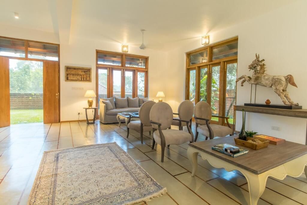 A spacious living room with a sofa set, a coffee table, and a rug.