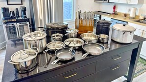 A kitchen with stainless steel appliances, a variety of pots and pans, and a knife block. - The Pearl - Waterfront Retreat  • 4BR • 7 Bed • Family / Friends / Pets (Colonial Beach)