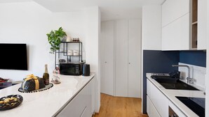 A modern kitchen with white cabinets, a built-in microwave, a sink, and a small plant. - Apartment 'Citrus Garden' with Mountain View, Wi-Fi and Air Conditioning (Cisano sul Neva)