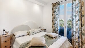 A bedroom with a bed, bedside tables, and curtains. - Apartment 'Citrus Garden' with Mountain View, Wi-Fi and Air Conditioning (Cisano sul Neva)