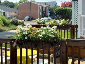 A wooden fence with flower planters, a brick building, and parked cars in the background. - 900. B Seaside 2 Br Cottage with Bay Views, Veranda, High Ceilings, Hot Tub, Private Beach, Beachfront Grilling, & Kayaks (Norfolk)