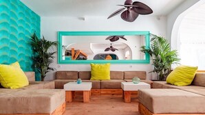 A modern living room with a sectional sofa, two white coffee tables, and a large mirror on the wall. - Beach Star Ibiza Hotel (Sant Josep de sa Talaia)