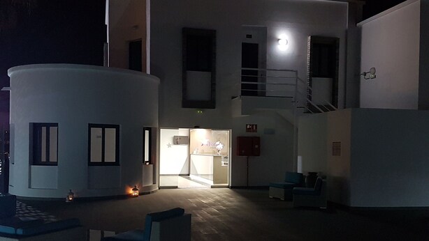 A two-story building with a reception area, a staircase, and a small outdoor seating area. - FBC Fortuny Resort - Adults Only (San Bartolomé de Tirajana)