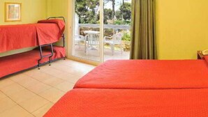 A room with two beds, a small table, and a chair. - Marinada Hotel (Salou)