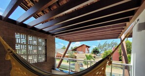 Un'amaca sotto un soffitto in legno con vista su una zona residenziale.