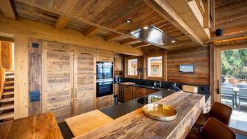 A modern kitchen with wooden cabinetry and a large island.