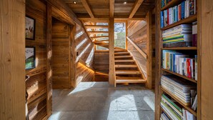 Ein Holzinnenraum mit einer Treppe zu einem Balkon, umgeben von Bücherregalen.