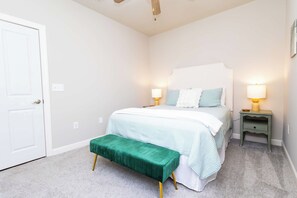 A bedroom with a bed, bedside lamps, a bench, and a door. - Rebel Bluff on Depot by Apex Short Term Stays (Oxford)