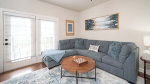 A living room with a gray sofa, a wooden coffee table, and a framed picture on the wall. - Rebel Bluff on Depot by Apex Short Term Stays (Oxford)