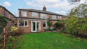 A two-story brick house with a front door, a small porch, and a green lawn. - Music Lovers | Piano | Pets OK & Driveway Parking (Liverpool)