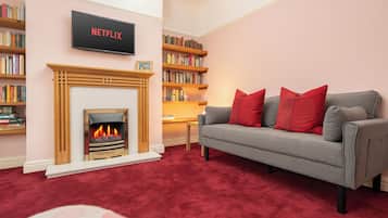 Smart-tv, eldstad, böcker och kontor