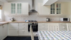 A kitchen with white cabinets, a microwave, a kettle, and a toaster. - Music Lovers | Piano | Pets OK & Driveway Parking (Liverpool)