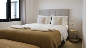 Ein ordentlich eingerichtetes Schlafzimmer mit einem Bett, zwei Nachttischen und einem Fenster.