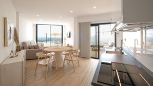 Una cocina moderna con comedor, ventanas amplias y vista al océano.