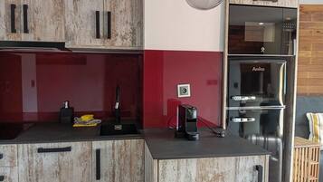 Eenvoudig appartement | Privékeuken | Een koelkast, een magnetron, een kookplaat, kookgerei, borden en bestek