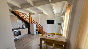 A compact living space with a kitchen, dining area, and a staircase leading to an upper level. - RIVIELLO ROOMS. (Marina di Camerota)