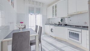 A modern kitchen with white cabinets, a built-in oven, and a washing machine. - Bijoux in the Centre of Sanremo by Wonderful Italy (Sanremo)