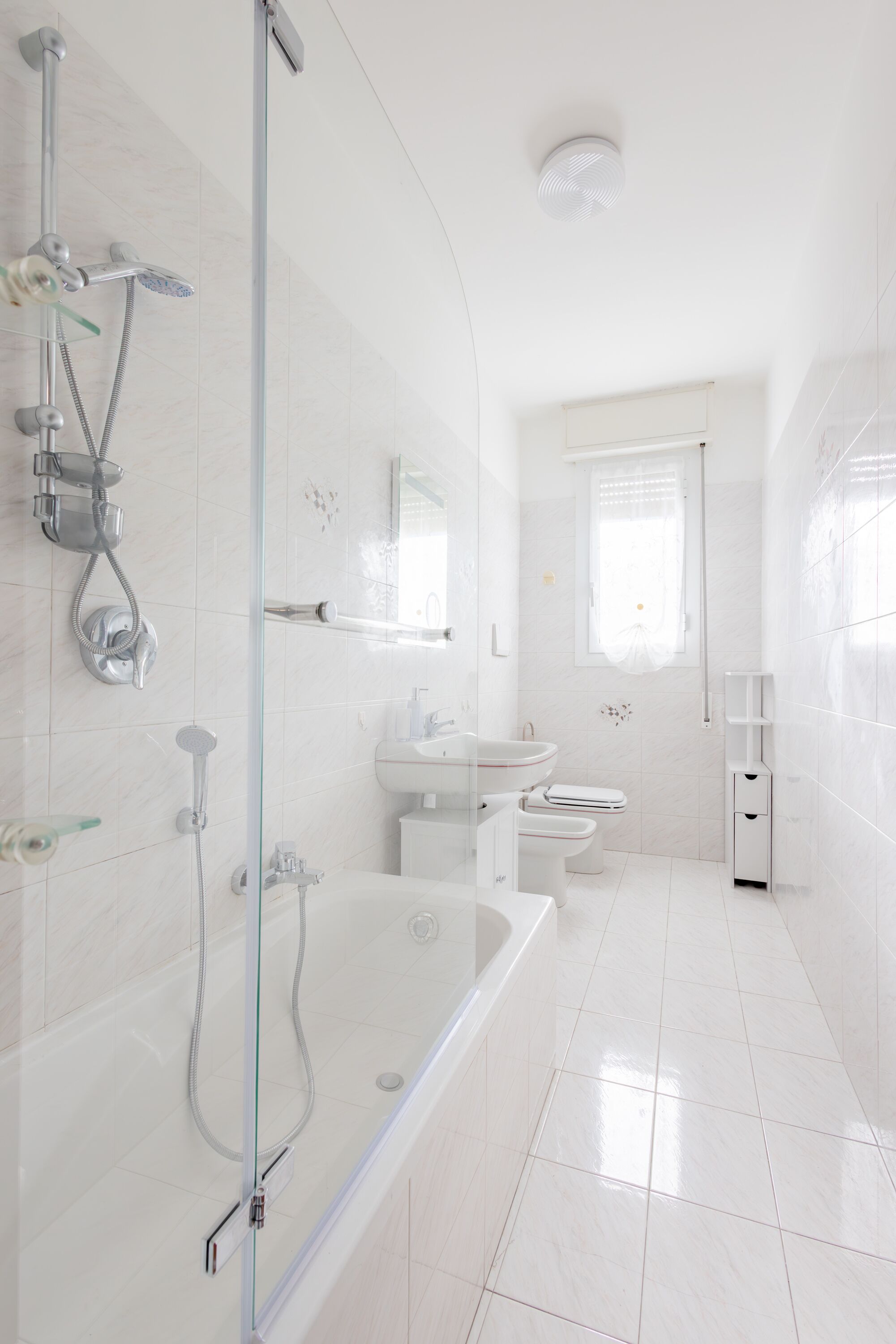 Un baño moderno con ducha envuelta en vidrio, bañera, inodoro y lavamanos.