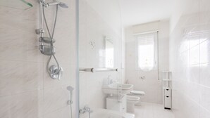 A modern bathroom with a glass-enclosed shower, a white sink, and a toilet. - Bijoux in the Centre of Sanremo by Wonderful Italy (Sanremo)