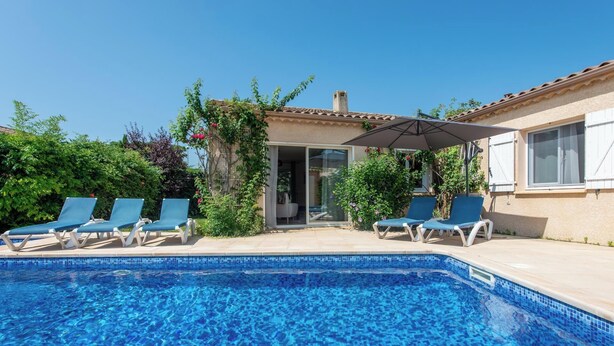 A swimming pool with clear blue water, surrounded by lounge chairs and a covered patio area. - La Bienvenue - Four Bedroom Villa, Sleeps 8 (Pézenas)