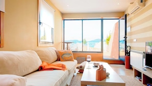 Un salon moderne avec un canapé, une table basse et une vue sur l’extérieur.