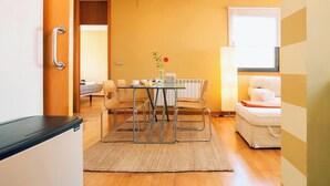Un espace de vie compact comprenant un coin repas, un canapé et un radiateur.