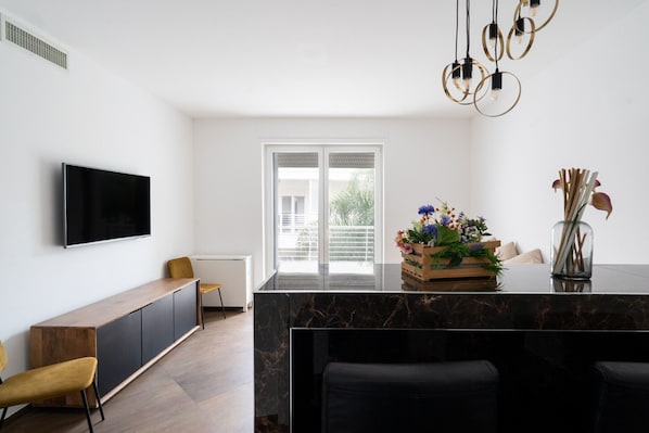 A modern kitchen with a marble countertop, a built-in TV, and a large window. - Martino's Home by Wonderful Italy (Polignano a Mare)