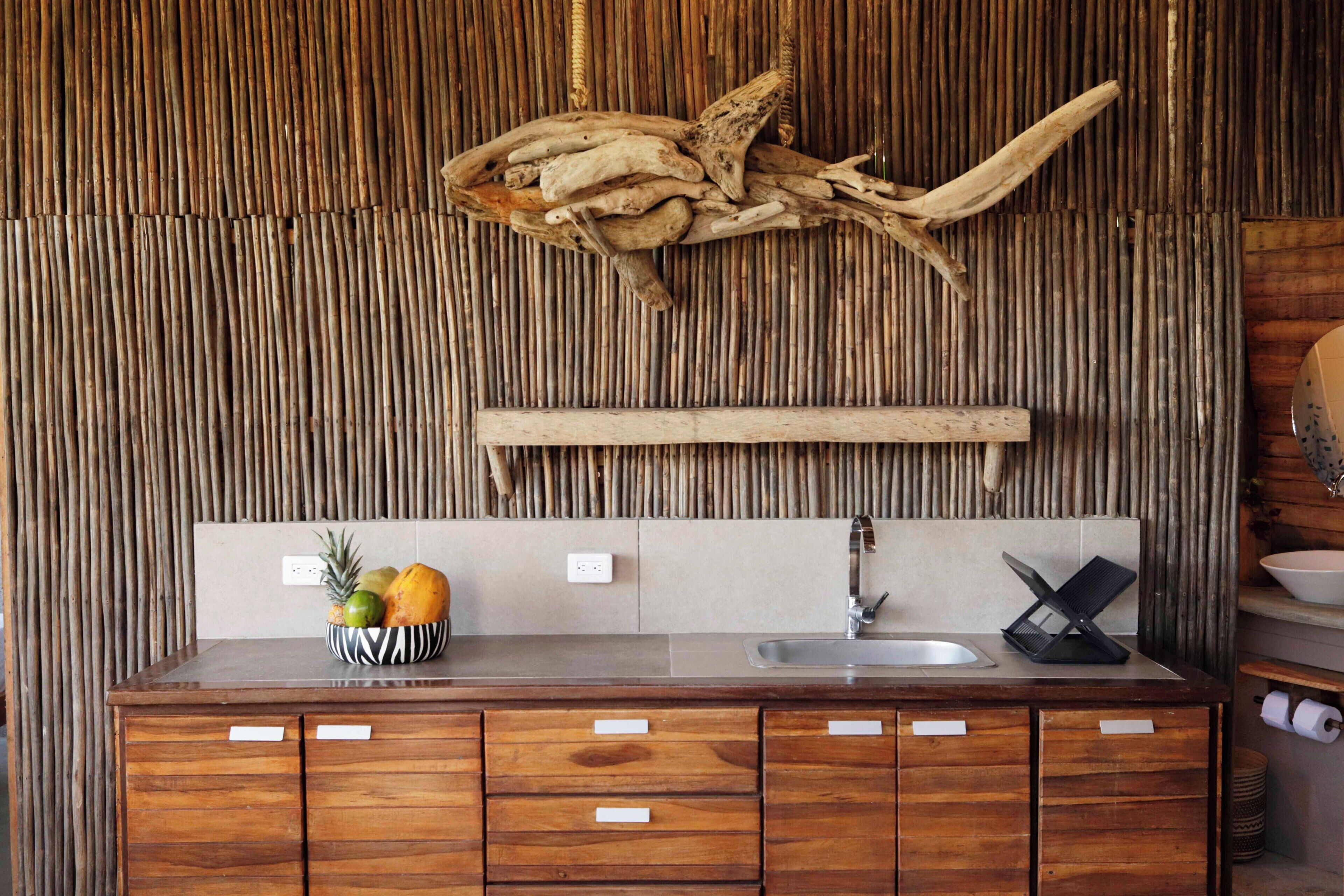 Una cocina con encimera de madera, un lavamanos y una pared decorativa con listones verticales.