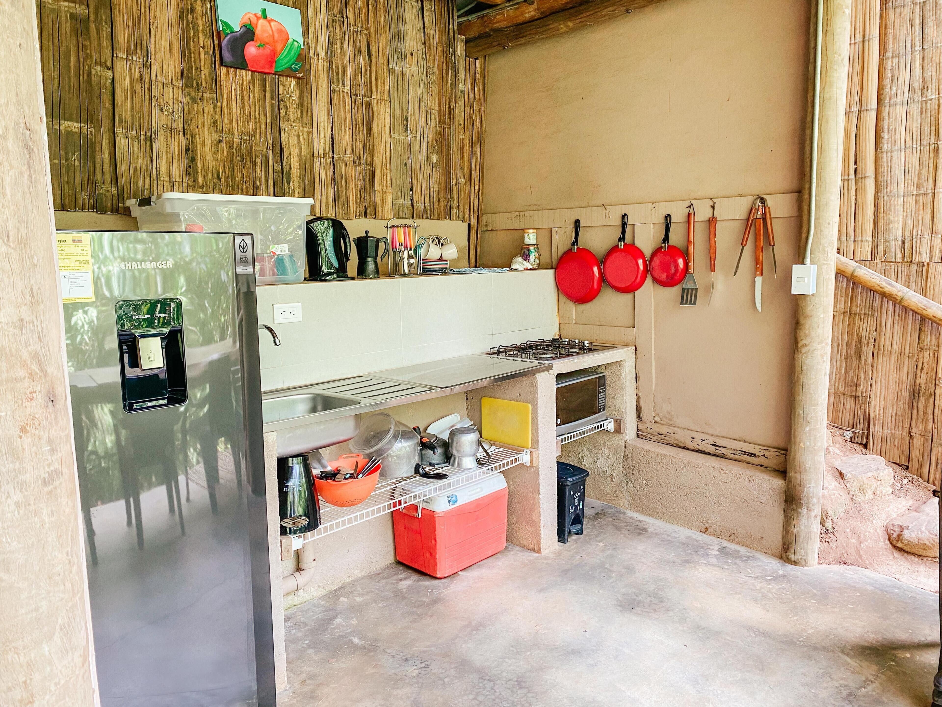 A compact kitchen with a refrigerator, stove, and various utensils.