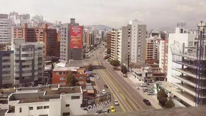 Paesaggio urbano con diversi edifici, tra cui un evidente cartello KFC su una costruzione alta.