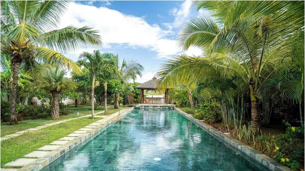 A swimming pool with a clear blue water, surrounded by palm trees and a gazebo. - Aroma Plaza Boutique Hotel (Cap Malheureux)