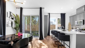 Une cuisine moderne dotée d’un îlot central, de tabourets de bar et d’une table à manger avec des chaises.