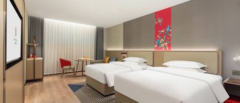 A hotel room with two beds, a desk, a chair, and a large window with curtains.