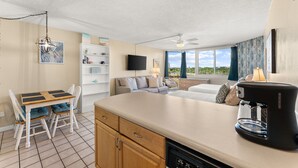 Eine moderne Küche mit Essbereich, einer Couch und einer Kaffeemaschine.