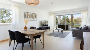 Una sala de estar moderna con comedor, ventanas grandes y un balcón.