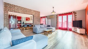 A modern living room with a sofa, a coffee table, and a TV stand. - Holiday Home 'Sleeps 22 Brem Center with Large' (Brem-sur-Mer)