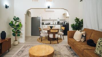 Un espace de vie compact comprenant un coin repas, une cuisine et un coin salon.