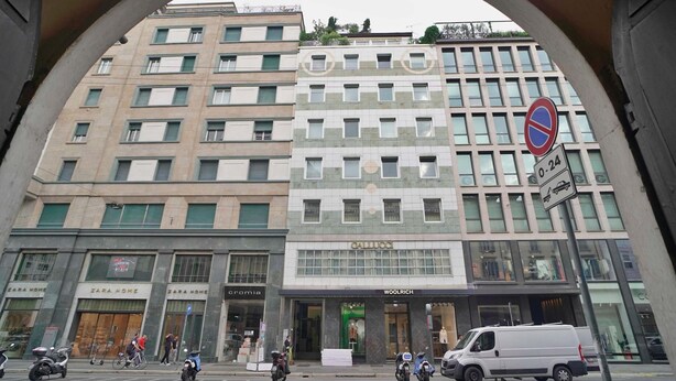 Un edificio a più piani con negozi al piano terra, tra cui Zara Home e Woolrich.