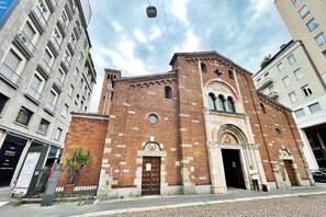 Un edificio storico con un imponente ingresso ad arco e una torre dell'orologio.