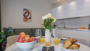 Una colazione con una ciotola di frutta, croissant e bicchieri di succo su un tavolo.