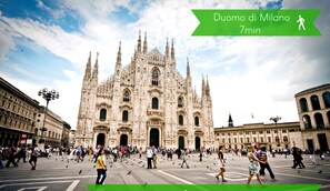 Una piazza affollata con una cattedrale storica sullo sfondo.