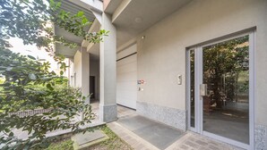 A building entrance with a glass door, a small outdoor area with a step, and a fire hydrant sign. - Palazzo Candiani - Deluxe Studio With Terrace (Milan)