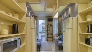 A modern kitchen with built-in appliances, a central island, and a view to the living area. - Cerva - Stylish 1 Bedroom Close to Duomo (Milan)