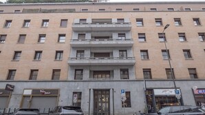 Ein mehrgeschossiges Gebäude mit Parkplatz davor.