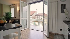 Eine moderne Wohnung mit Balkon, Essbereich und Küche.
