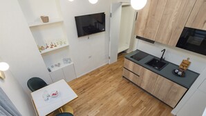 Een compacte keuken met een eethoek, houten vloeren en moderne apparatuur.
