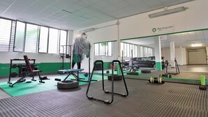A gym with exercise equipment, a large mirror, and a sign for Rentopolis. - Candiani Building - Modern 2BR Apartment Steps From Bovisa Politecnico (Milan)
